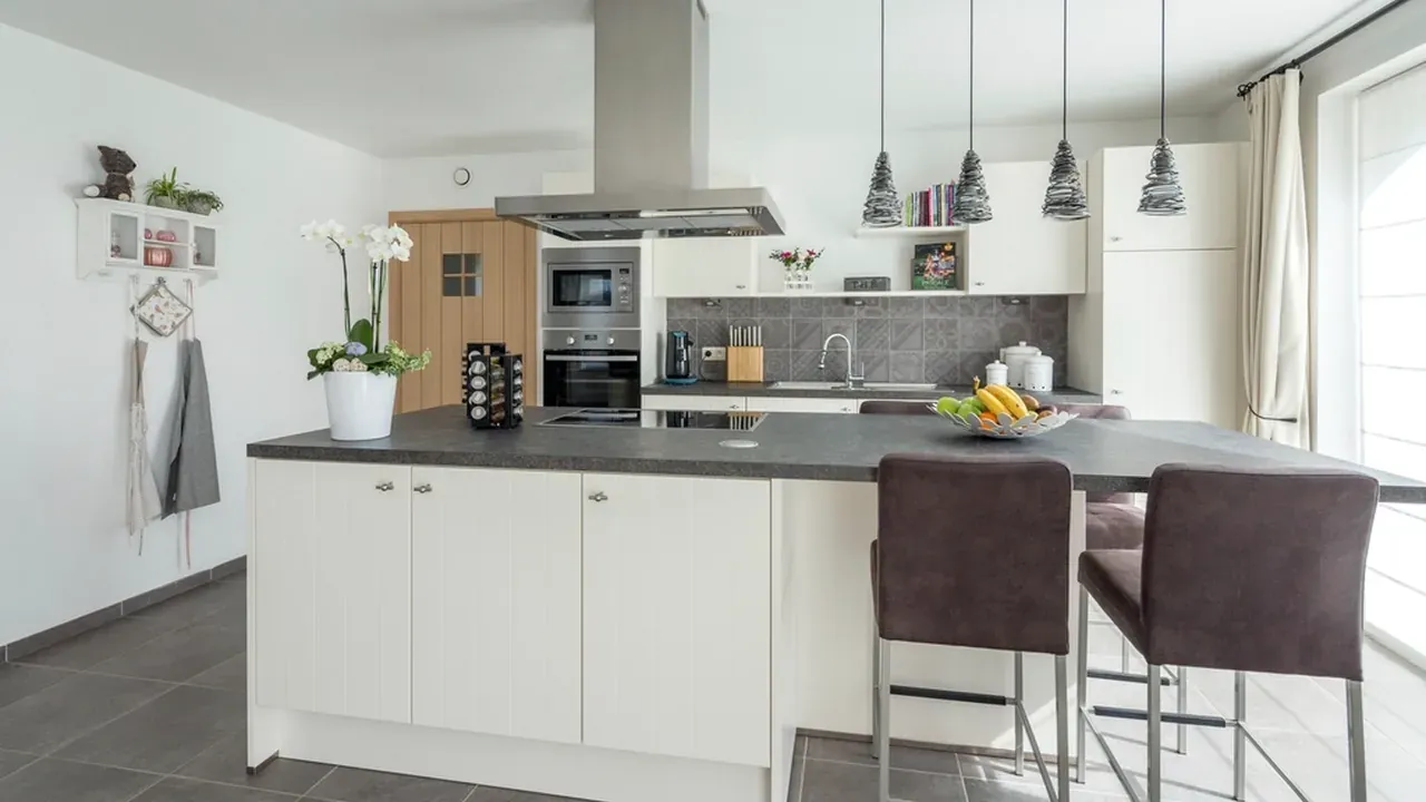Cuisine moderne terminée avec armoires blanches et îlot central